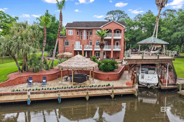 back of house featuring a gazebo, a water view, a patio, and boat lift