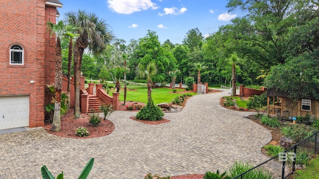 view of home's community featuring view of scattered trees, a garage, driveway, and stairway