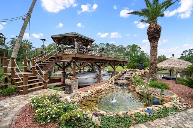 view of property's community with stairs, a garden pond, and a gazebo