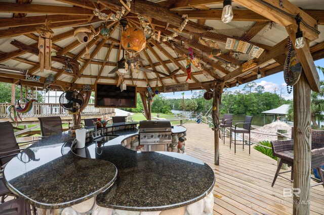wooden deck featuring a gazebo, outdoor dining space, and area for grilling