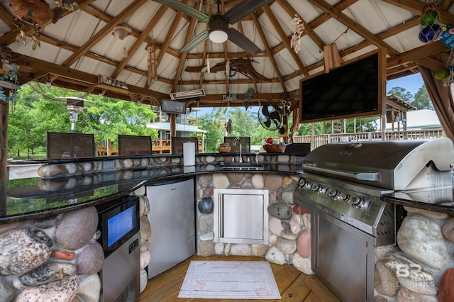view of patio with a gazebo, exterior kitchen, a sink, ceiling fan, and area for grilling