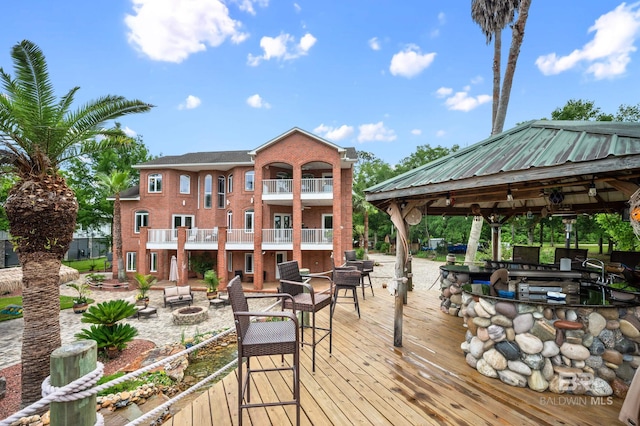 wooden terrace with a fire pit and a gazebo