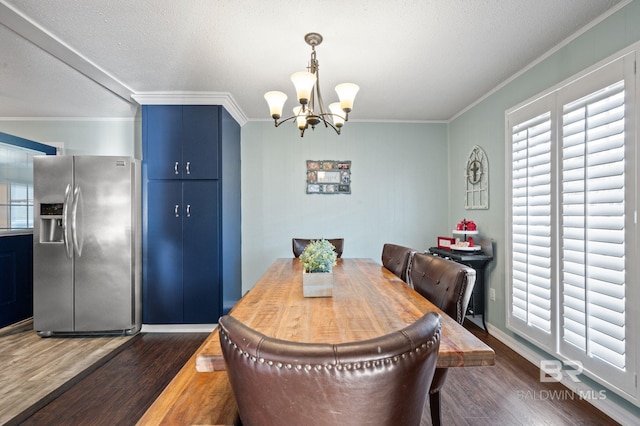 dining area featuring crown molding, dark wood-type flooring, and a chandelier