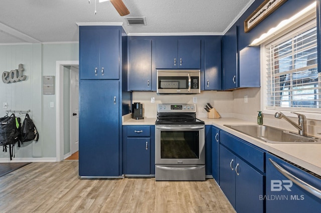 kitchen featuring sink, stainless steel appliances, a textured ceiling, and blue cabinetry