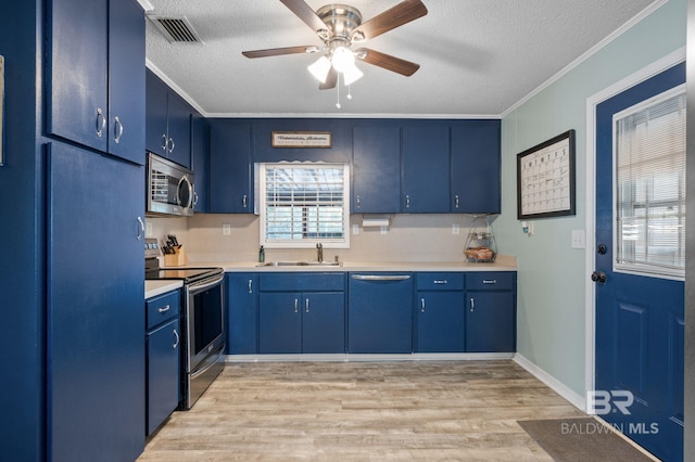 kitchen with stainless steel appliances, sink, blue cabinets, and a textured ceiling