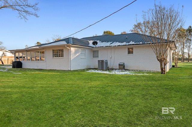 back of house with a yard and central AC