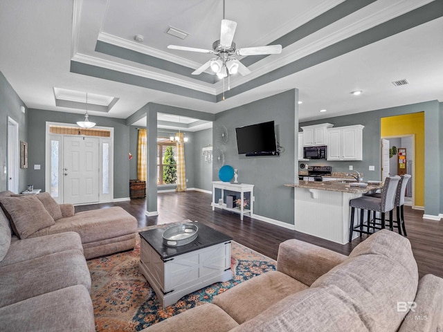 17163 Feder Dr, Foley, AL 36535 - living room with a tray ceiling, baseboards, dark wood-type flooring, and visible vents