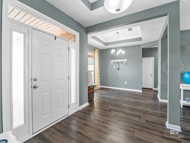 17163 Feder Dr, Foley, AL 36535 - foyer entrance with a tray ceiling, dark wood-style flooring, baseboards, visible vents, and a notable chandelier
