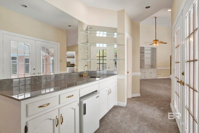 6805 Hunters Ct, Mobile, AL 36695 - kitchen with french doors, a sink, light colored carpet, white cabinetry, and a ceiling fan