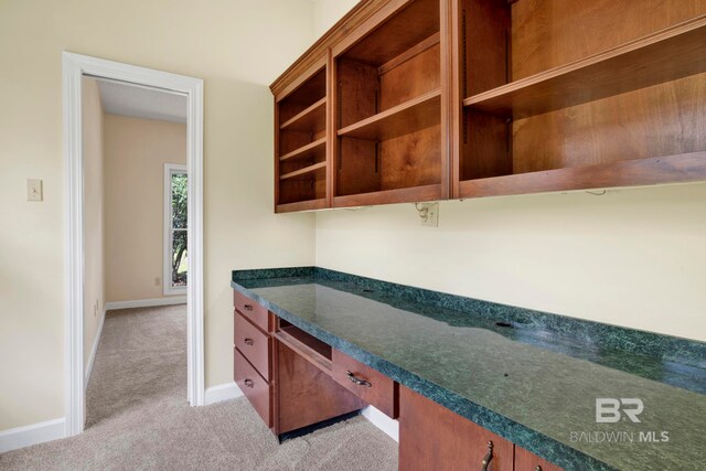 6805 Hunters Ct, Mobile, AL 36695 - kitchen with light colored carpet, dark countertops, baseboards, and brown cabinetry