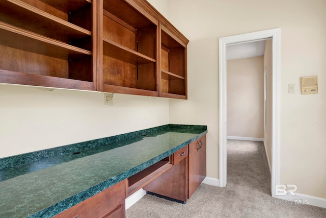 6805 Hunters Ct, Mobile, AL 36695 - kitchen with light carpet, dark countertops, baseboards, open shelves, and brown cabinets