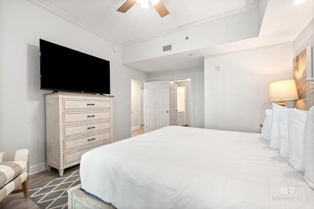 bedroom featuring visible vents, ornamental molding, wood finished floors, baseboards, and a ceiling fan