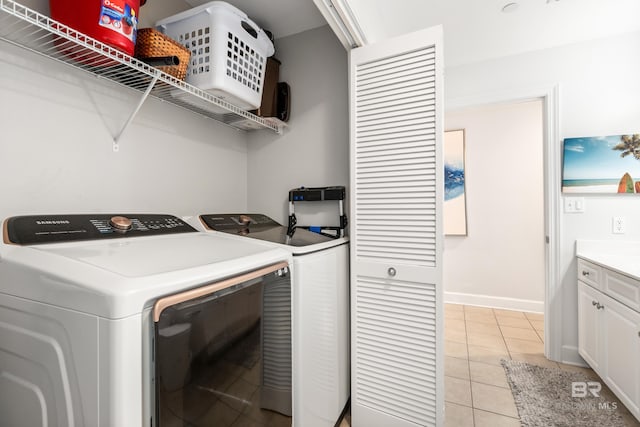 clothes washing area featuring washer and dryer, baseboards, light tile patterned floors, and laundry area