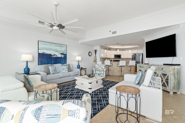 living room with crown molding, light tile patterned floors, ceiling fan, and visible vents