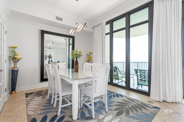 dining space with crown molding, light tile patterned flooring, visible vents, and a chandelier