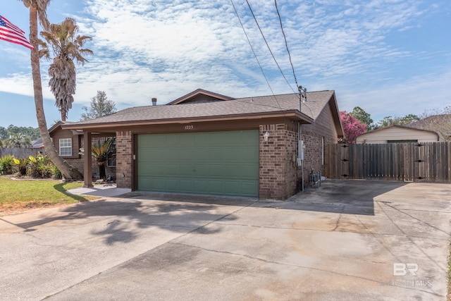 view of front of property featuring a garage, brick siding, and fence