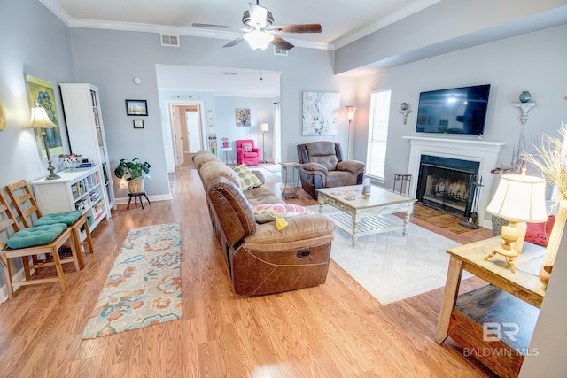 living room with light hardwood / wood-style flooring, ceiling fan, and crown molding