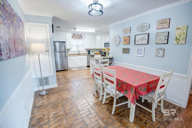 dining area featuring sink and ornamental molding