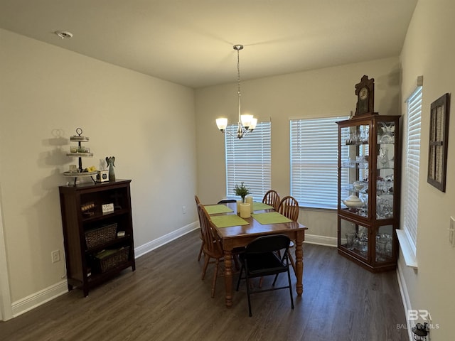 dining area with dark hardwood / wood-style flooring and a notable chandelier