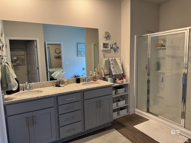 bathroom featuring hardwood / wood-style flooring, vanity, and a shower with door