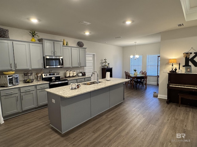 kitchen featuring sink, stainless steel appliances, a center island with sink, and pendant lighting