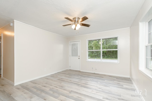 spare room with a textured ceiling, ceiling fan, crown molding, and light wood-type flooring