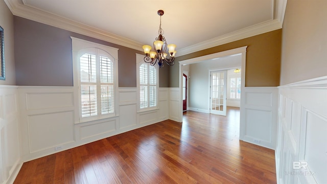 unfurnished dining area featuring hardwood / wood-style flooring, ornamental molding, and a wealth of natural light