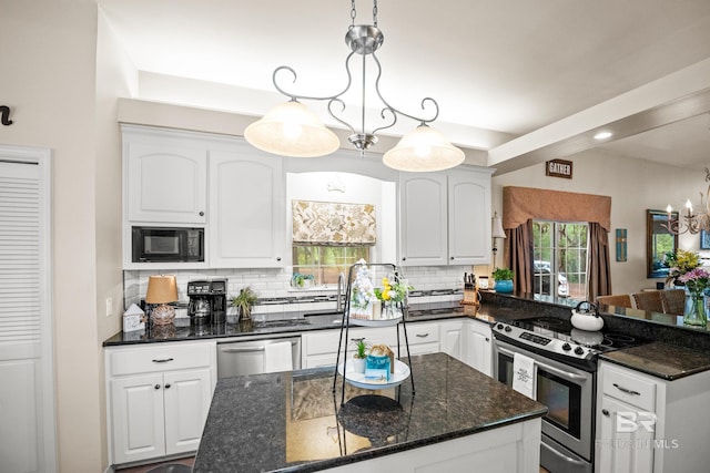 11346 County Road 99, Lillian, AL 36549 - kitchen with appliances with stainless steel finishes, healthy amount of natural light, backsplash, and white cabinets