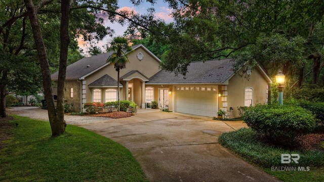 11346 County Road 99, Lillian, AL 36549 - view of front of house with stucco siding, an attached garage, and driveway