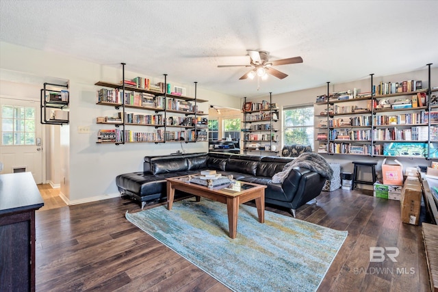 living room with ceiling fan, a textured ceiling, and dark hardwood / wood-style flooring