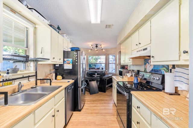 kitchen with light hardwood / wood-style flooring, sink, a notable chandelier, white cabinetry, and appliances with stainless steel finishes