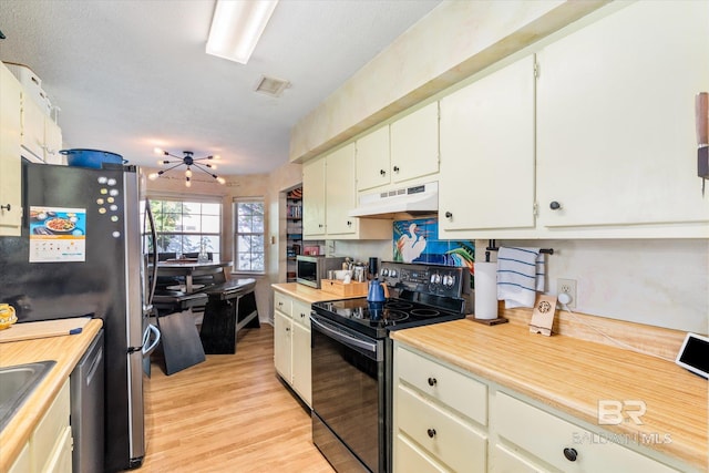 kitchen featuring a chandelier, white cabinetry, stainless steel appliances, and light hardwood / wood-style floors