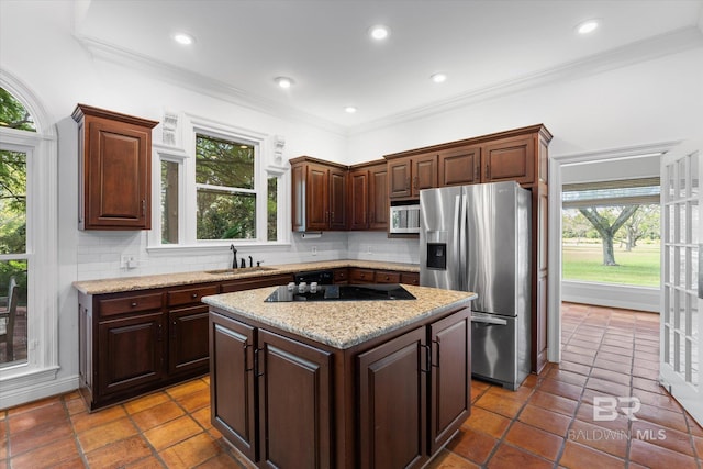 kitchen with a center island, backsplash, stainless steel fridge with ice dispenser, and a wealth of natural light