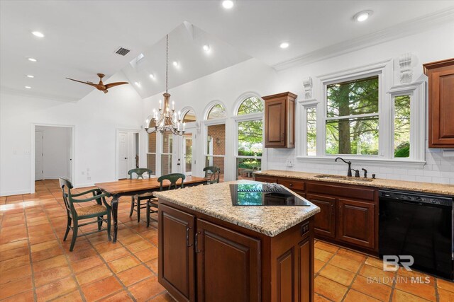 kitchen featuring tasteful backsplash, sink, ceiling fan with notable chandelier, a kitchen island, and black appliances