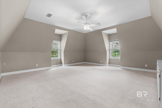 bonus room with light carpet, vaulted ceiling, ceiling fan, and plenty of natural light