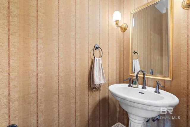 bathroom featuring wood walls and sink