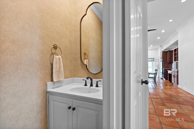 bathroom with tile patterned flooring, vanity, and crown molding