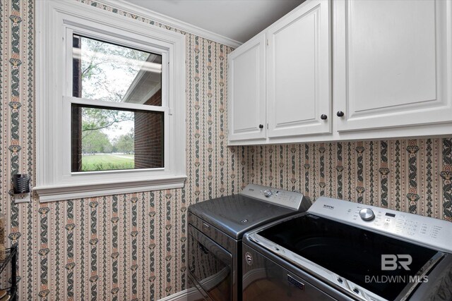 laundry area with cabinets, washing machine and clothes dryer, and ornamental molding