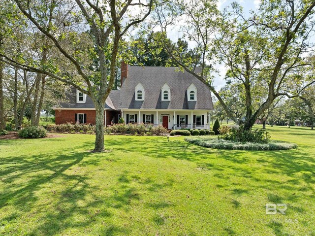 new england style home with a porch and a front lawn