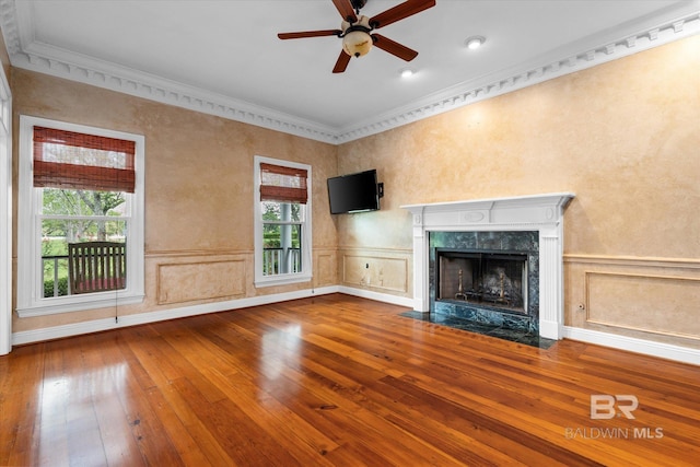 unfurnished living room featuring crown molding, hardwood / wood-style floors, ceiling fan, and a premium fireplace