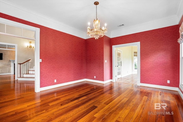 unfurnished room with wood-type flooring, crown molding, and a chandelier