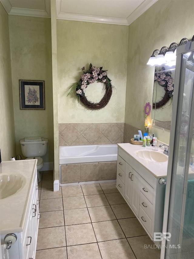 bathroom with a relaxing tiled bath, vanity, toilet, and crown molding