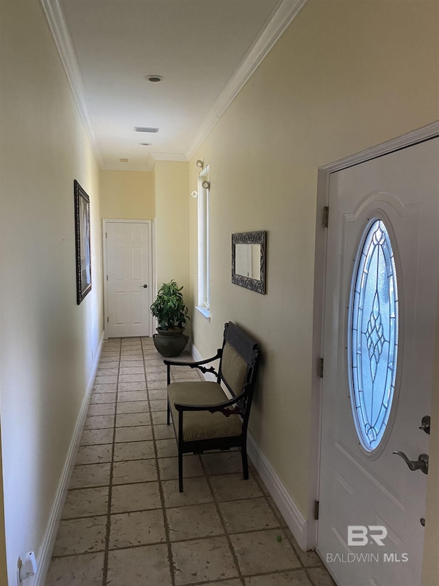 tiled foyer featuring crown molding