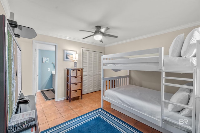 tiled bedroom with connected bathroom, a closet, ceiling fan, baseboards, and crown molding