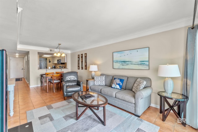 living area with light tile patterned flooring, crown molding, a notable chandelier, and baseboards