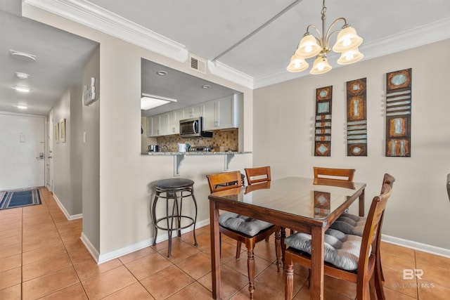 dining space featuring light tile patterned floors, visible vents, baseboards, ornamental molding, and a notable chandelier