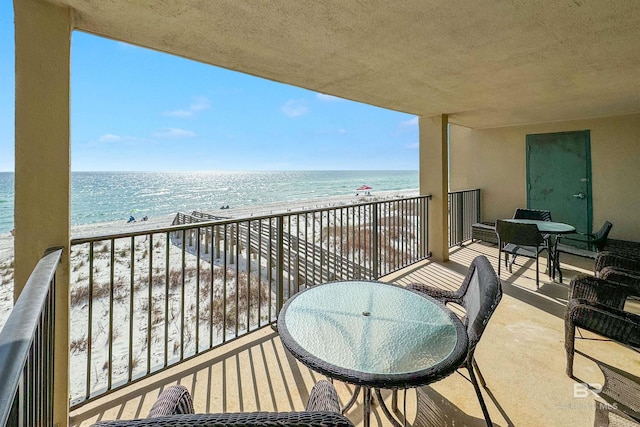 balcony featuring a water view and a view of the beach