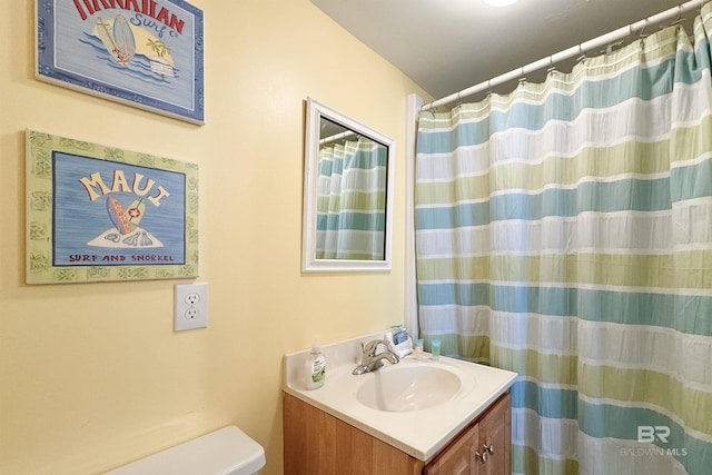 bathroom featuring curtained shower, vanity, and toilet