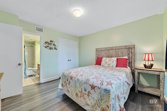 bedroom with a closet, a textured ceiling, visible vents, and wood finished floors