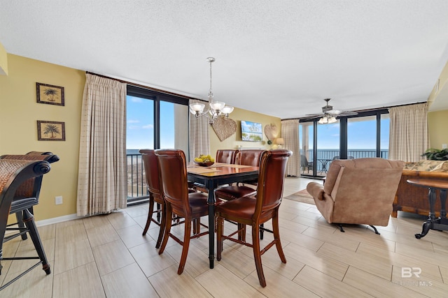 dining space featuring expansive windows, plenty of natural light, and ceiling fan with notable chandelier